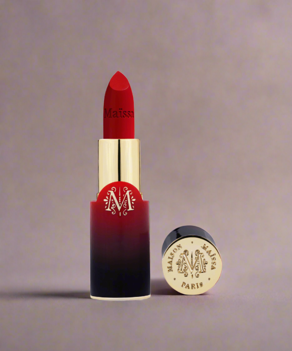 Red lipstick with gold cap and 'Maison M' branding on a beige background