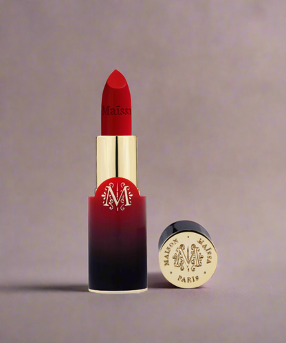 Red lipstick with gold cap and 'Maison M' branding on a beige background